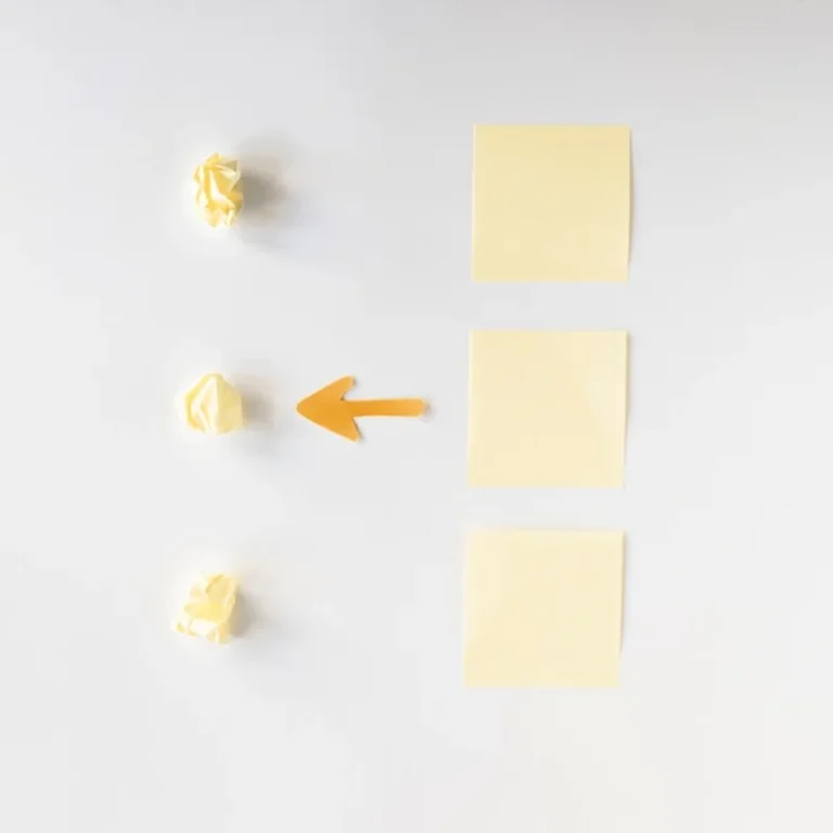 Symbol strzałki między papierami i karteczkami samoprzylepnymi