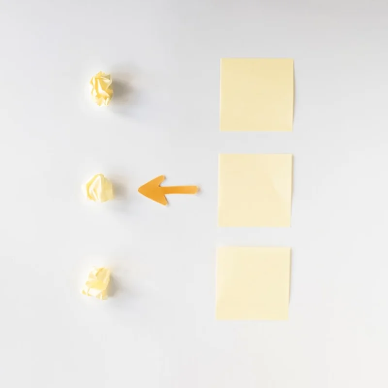 Symbol strzałki między papierami i karteczkami samoprzylepnymi