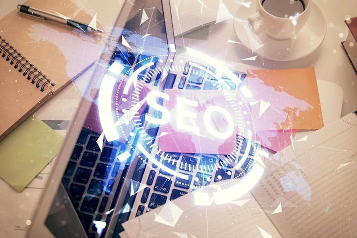 Podwójna ekspozycja rysunku SEO na tle stołu z komputerem