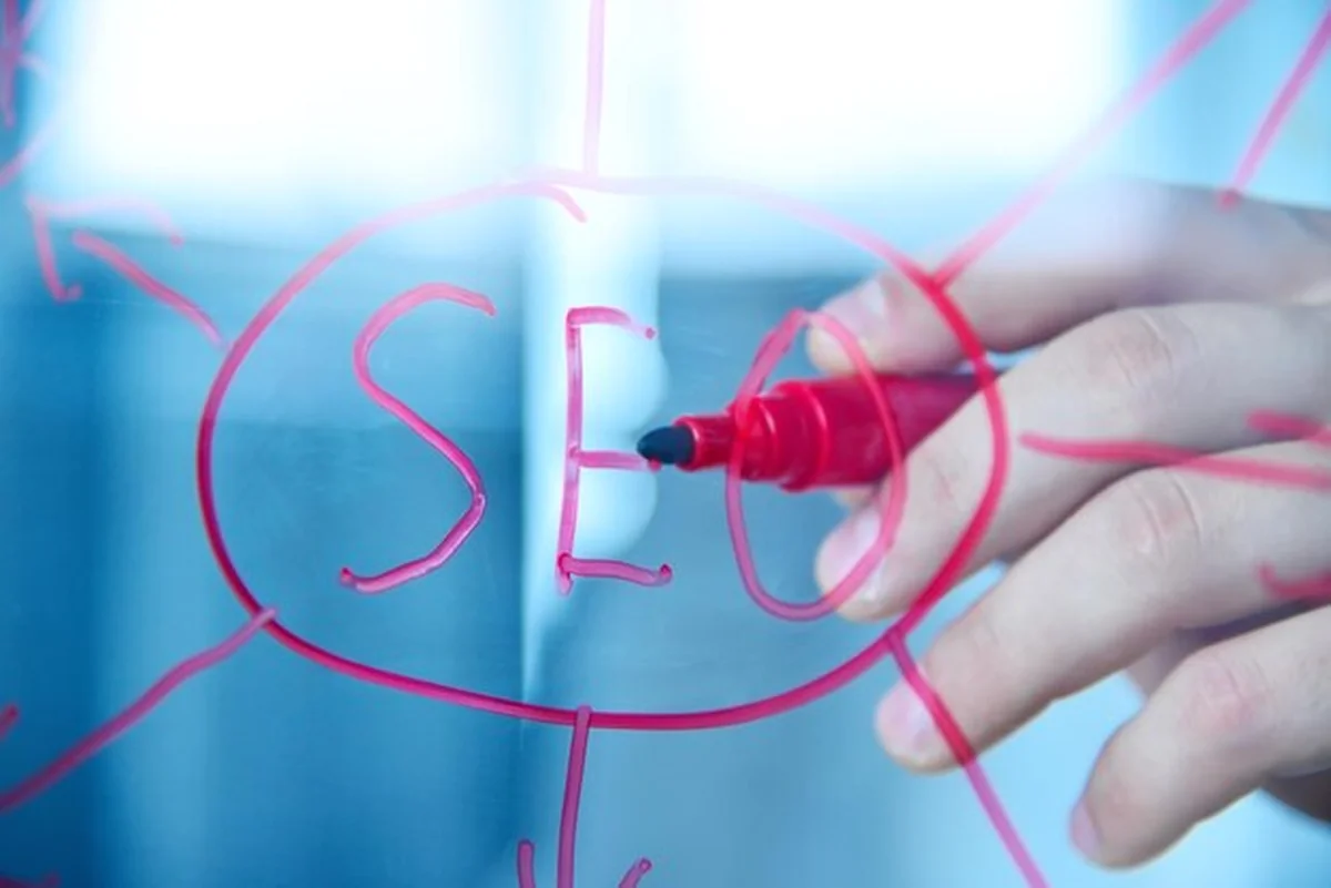 Ręka pisząca schemat SEO na ekranie przezroczystym