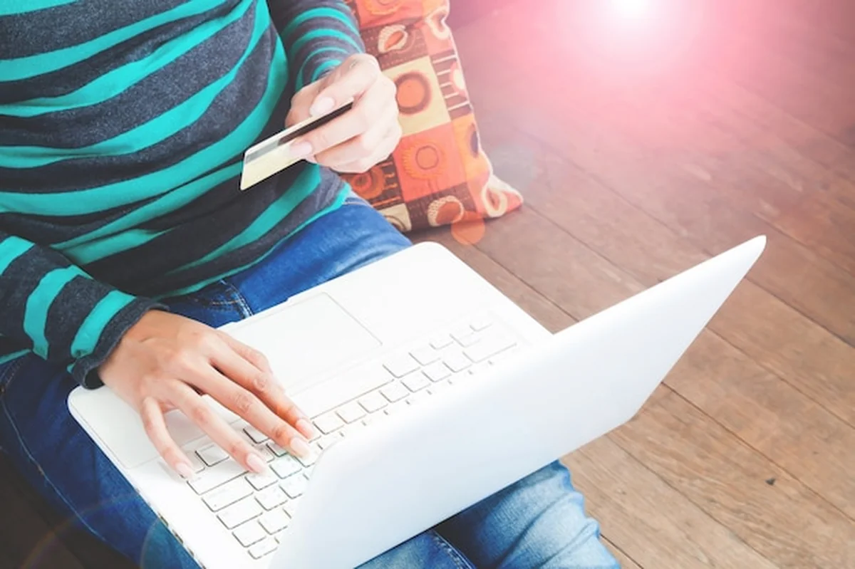 Kobieta z laptopem i kartą kredytową w domu