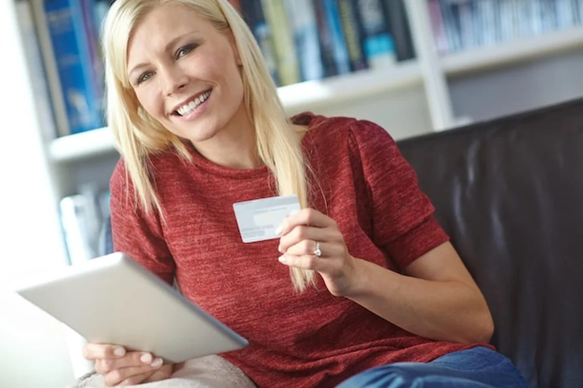 Kobieta z tabletem z kartą kredytową do zakupów online