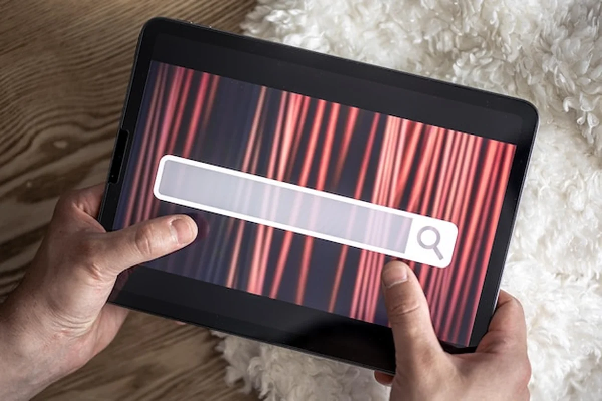 Cyfrowy tablet z paskiem wyszukiwania na ekranie w rękach mężczyzny