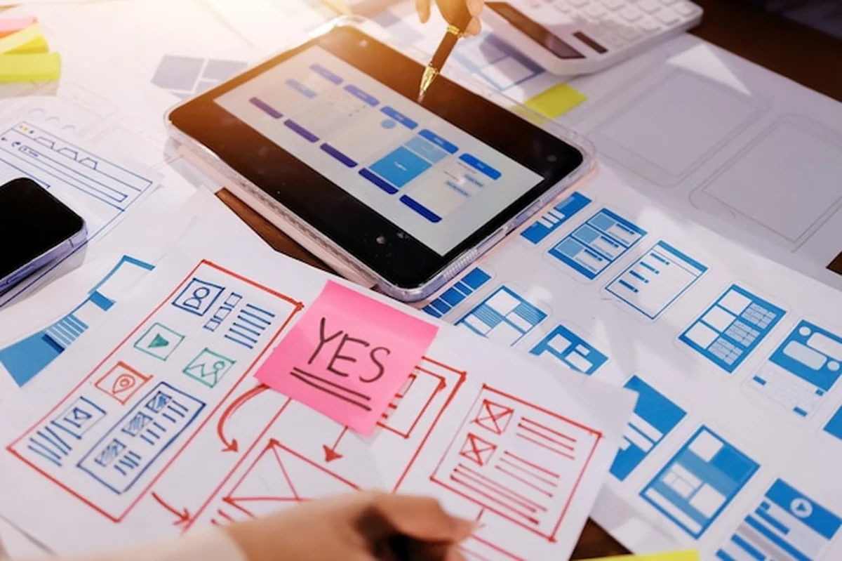 Dwa specjaliści UX i UI projektują interfejs aplikacji mobilnej w nowoczesnym biurze